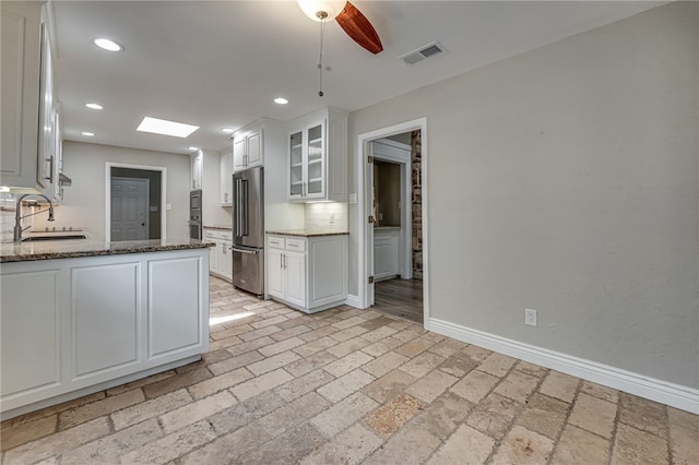 kitchen with white cabinets, sink, decorative backsplash, ceiling fan, and stainless steel appliances