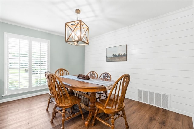 dining space with hardwood / wood-style floors, ornamental molding, a wealth of natural light, and a chandelier