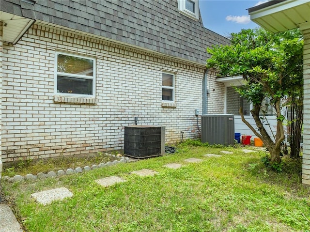 view of side of property featuring a yard and cooling unit