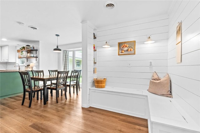 dining area featuring wooden walls and light hardwood / wood-style flooring