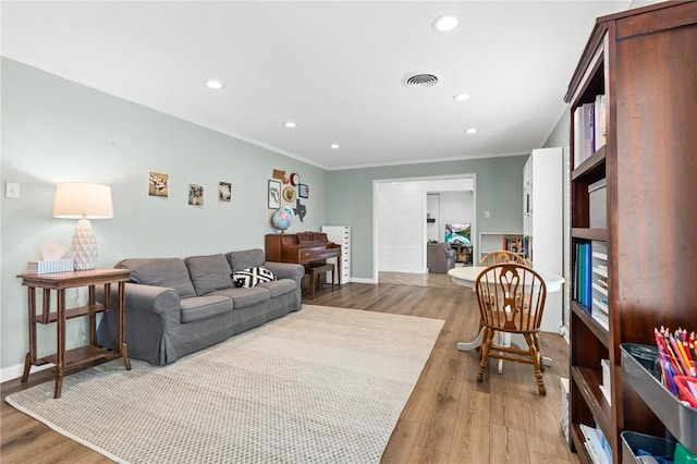 living room featuring light wood-type flooring and ornamental molding