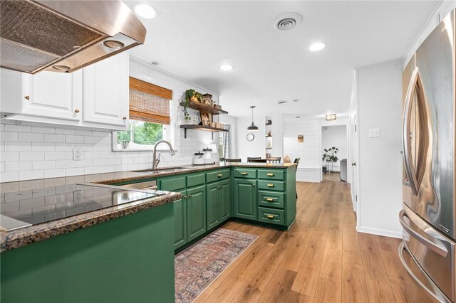 kitchen with green cabinetry, light hardwood / wood-style flooring, stainless steel fridge, island range hood, and white cabinetry