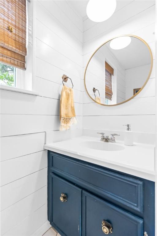 bathroom with wood walls and vanity