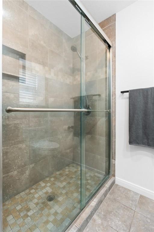 bathroom featuring tile patterned flooring and an enclosed shower