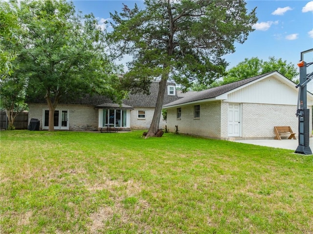 back of house featuring a lawn and a patio area