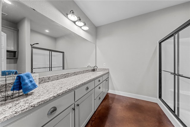 bathroom with vanity, concrete floors, and a shower with shower door