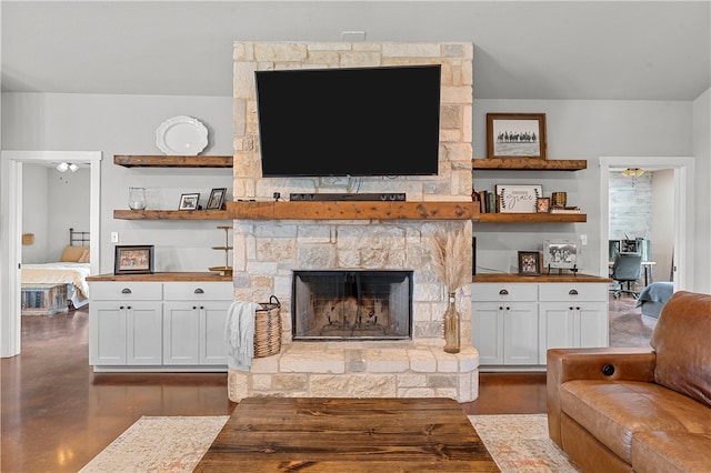 living room with ceiling fan and a fireplace