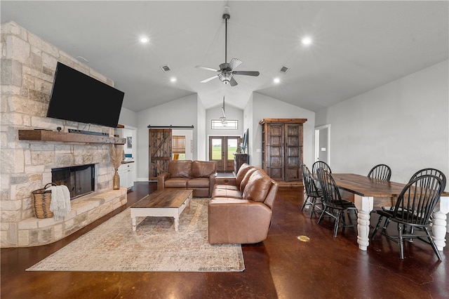 living room with a barn door, high vaulted ceiling, a stone fireplace, and ceiling fan