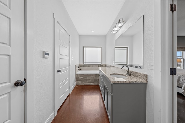 bathroom featuring vanity and a relaxing tiled tub