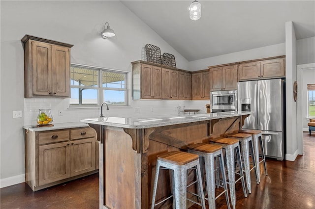 kitchen with a healthy amount of sunlight, a center island, high vaulted ceiling, and stainless steel appliances