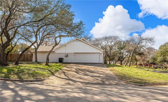 view of front of property featuring a garage, central AC, and a front lawn