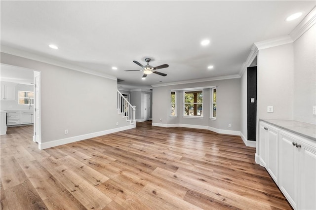 unfurnished living room featuring crown molding, ceiling fan, and light wood-type flooring