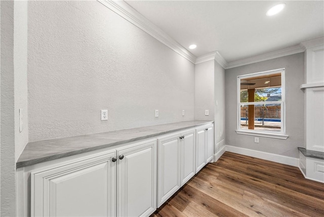 interior space featuring white cabinetry, hardwood / wood-style floors, and crown molding