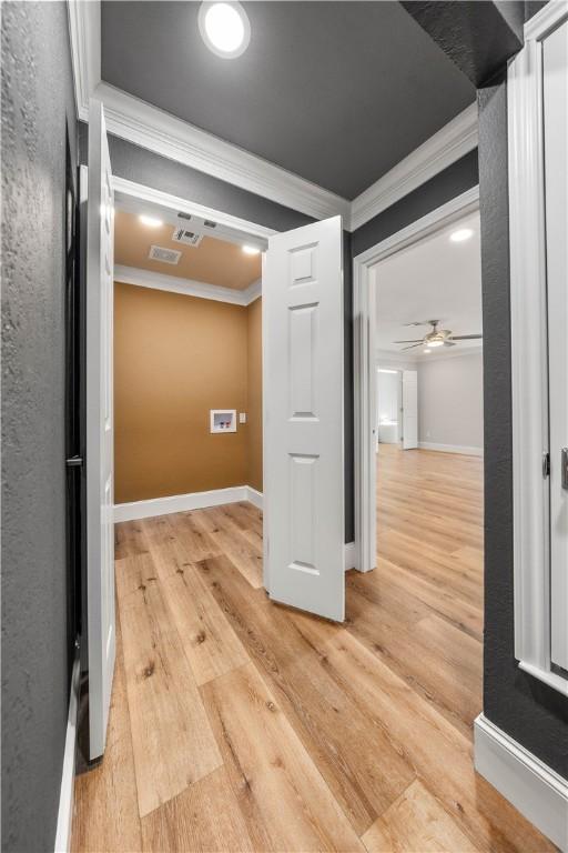 interior space featuring ornamental molding and light wood-type flooring