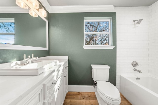 full bathroom with crown molding, hardwood / wood-style floors, vanity, toilet, and tiled shower / bath