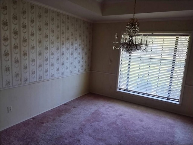 empty room featuring carpet and a notable chandelier