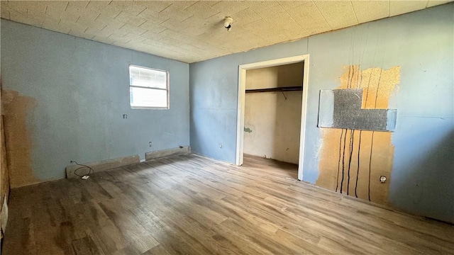 unfurnished bedroom with wood-type flooring and a closet