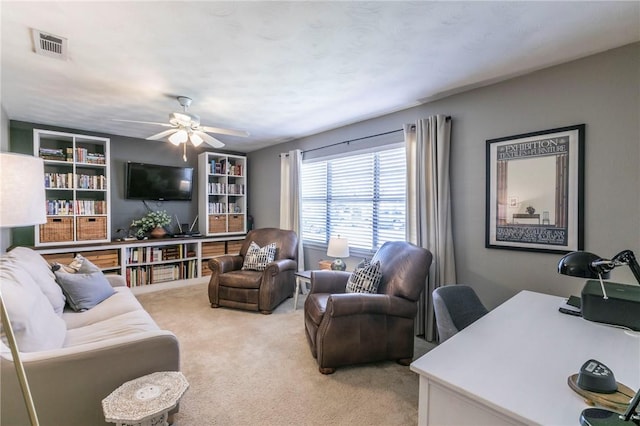 living room featuring a ceiling fan, light carpet, and visible vents