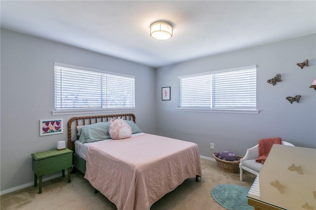 bedroom featuring light carpet and baseboards