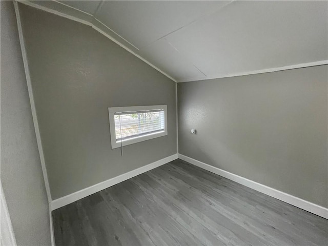 empty room with hardwood / wood-style flooring and vaulted ceiling