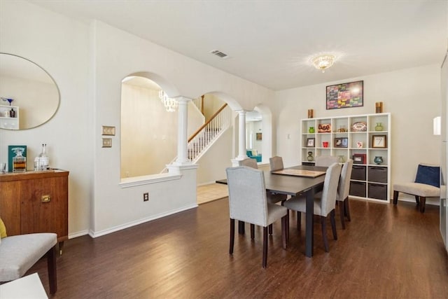 dining area with ornate columns and dark hardwood / wood-style floors