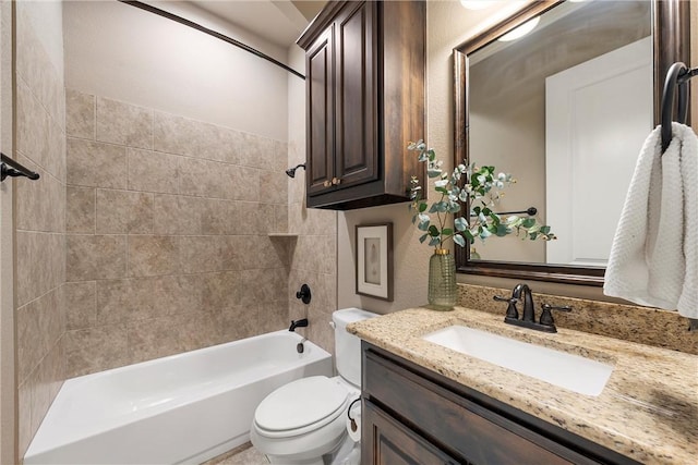 full bathroom featuring tiled shower / bath, vanity, and toilet