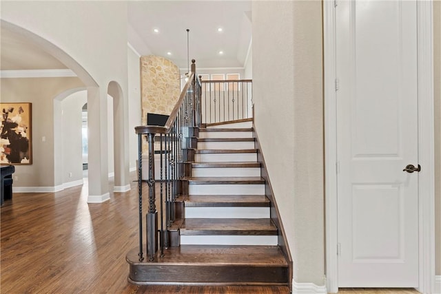 stairway with hardwood / wood-style flooring and ornamental molding