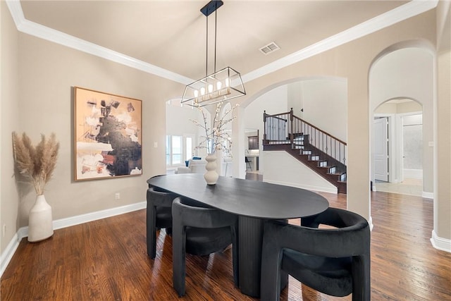 dining space with dark hardwood / wood-style flooring, a notable chandelier, and ornamental molding