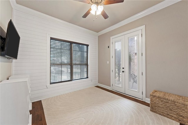 interior space with ornamental molding, hardwood / wood-style floors, ceiling fan, and french doors