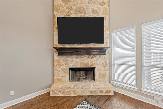 interior details with a stone fireplace and hardwood / wood-style floors