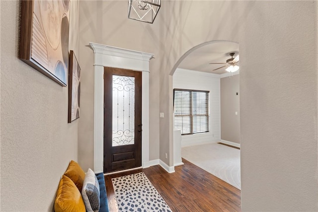 entryway with ceiling fan, ornamental molding, and dark hardwood / wood-style floors