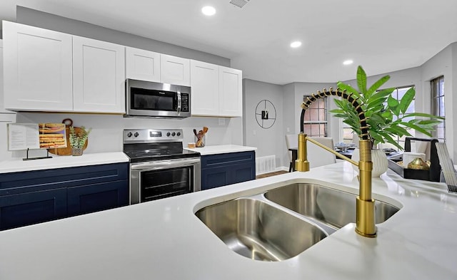 kitchen featuring appliances with stainless steel finishes, sink, and white cabinets