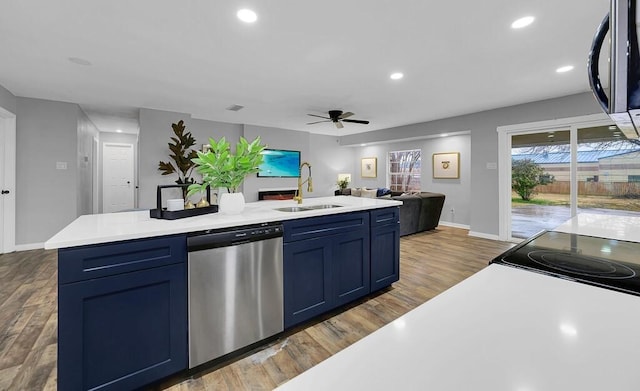 kitchen featuring blue cabinetry, sink, a center island with sink, dark hardwood / wood-style floors, and dishwasher