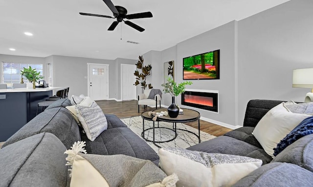 living room featuring ceiling fan and dark hardwood / wood-style floors