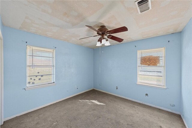 unfurnished room with carpet flooring, ceiling fan, and a healthy amount of sunlight