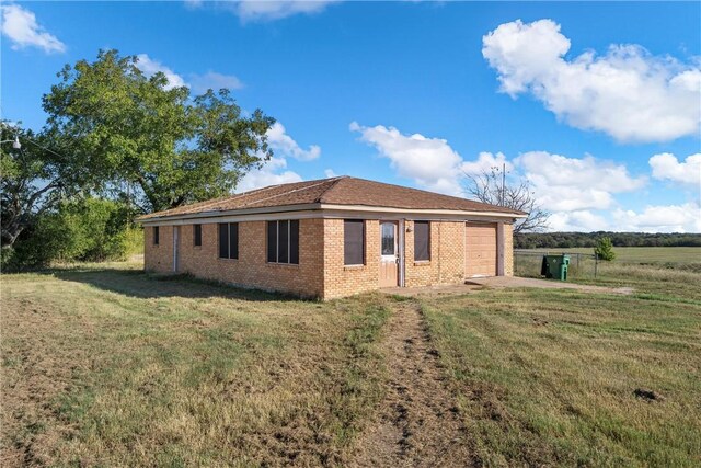 view of side of property featuring a yard and a garage