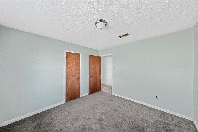 unfurnished bedroom featuring a textured ceiling and light carpet