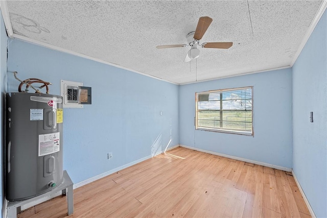 interior space with light wood-type flooring, a textured ceiling, electric water heater, and ornamental molding