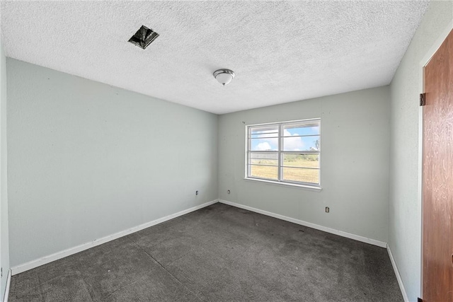 carpeted spare room featuring a textured ceiling