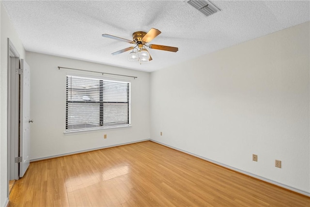 spare room with a textured ceiling, hardwood / wood-style flooring, and ceiling fan