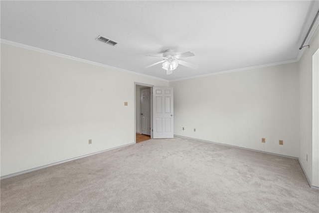 empty room featuring ceiling fan, light colored carpet, and ornamental molding