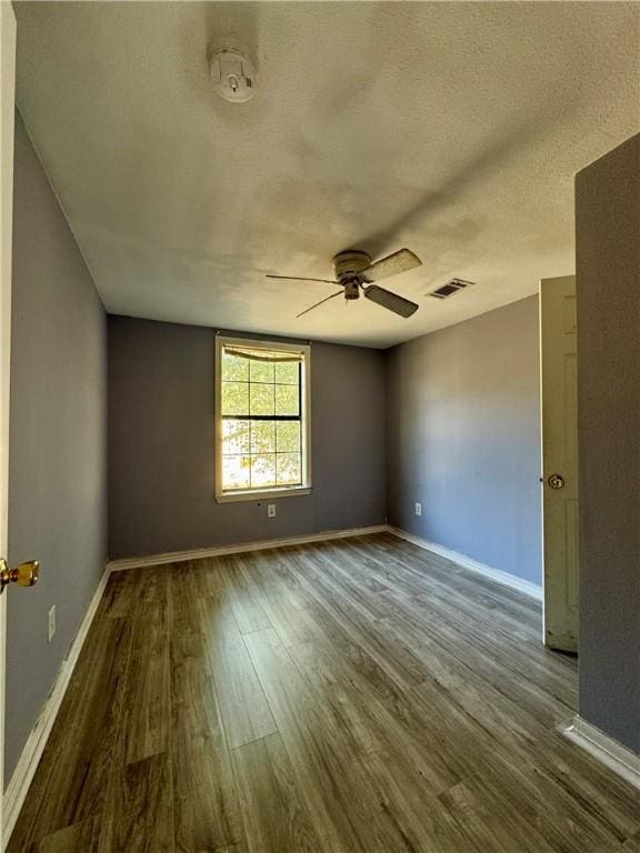 unfurnished room with ceiling fan, a textured ceiling, and hardwood / wood-style flooring