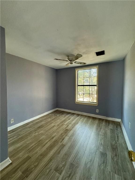 unfurnished room with ceiling fan and dark wood-type flooring