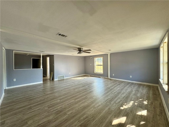 spare room featuring ceiling fan, dark wood-type flooring, and a textured ceiling