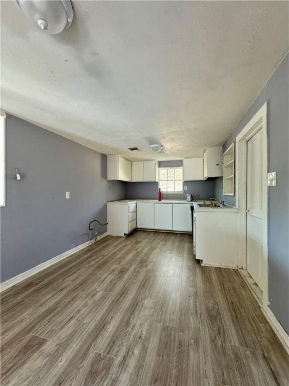 kitchen featuring white cabinetry, a textured ceiling, and hardwood / wood-style flooring