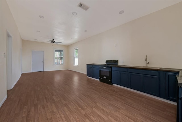 unfurnished living room with hardwood / wood-style floors, ceiling fan, and sink