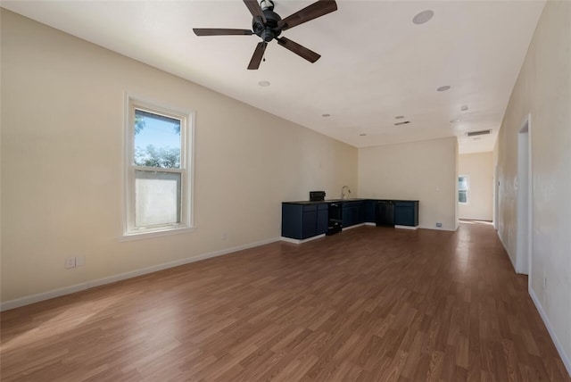 unfurnished living room featuring dark hardwood / wood-style floors and ceiling fan