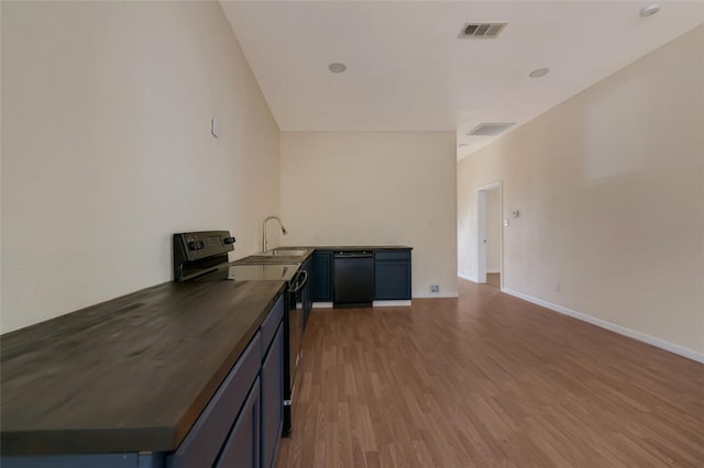 kitchen with black appliances, sink, kitchen peninsula, and hardwood / wood-style floors