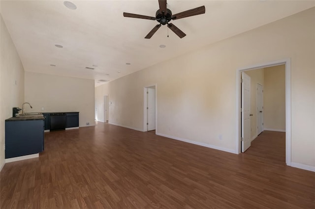 unfurnished living room with dark hardwood / wood-style flooring, ceiling fan, and sink