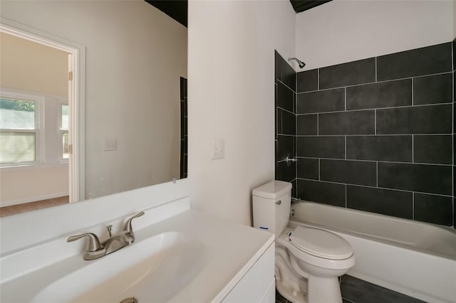 full bathroom featuring vanity, tiled shower / bath combo, and toilet